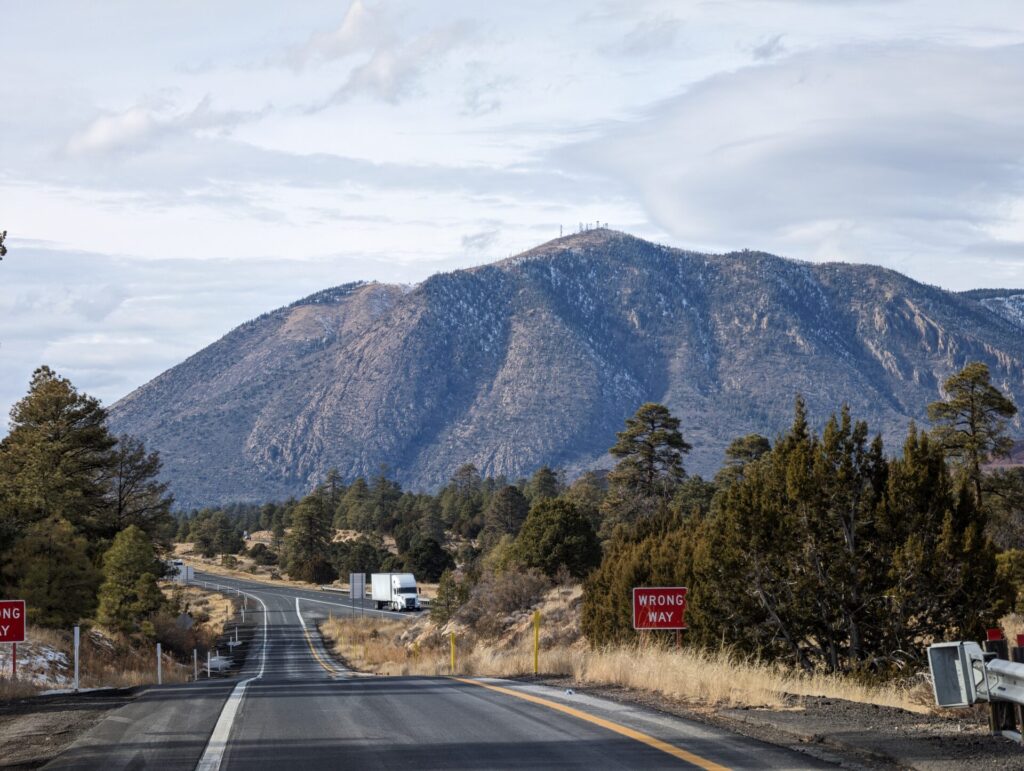 Image of Flagstaff, Arizona with a road at the forefront and a mountain in the background